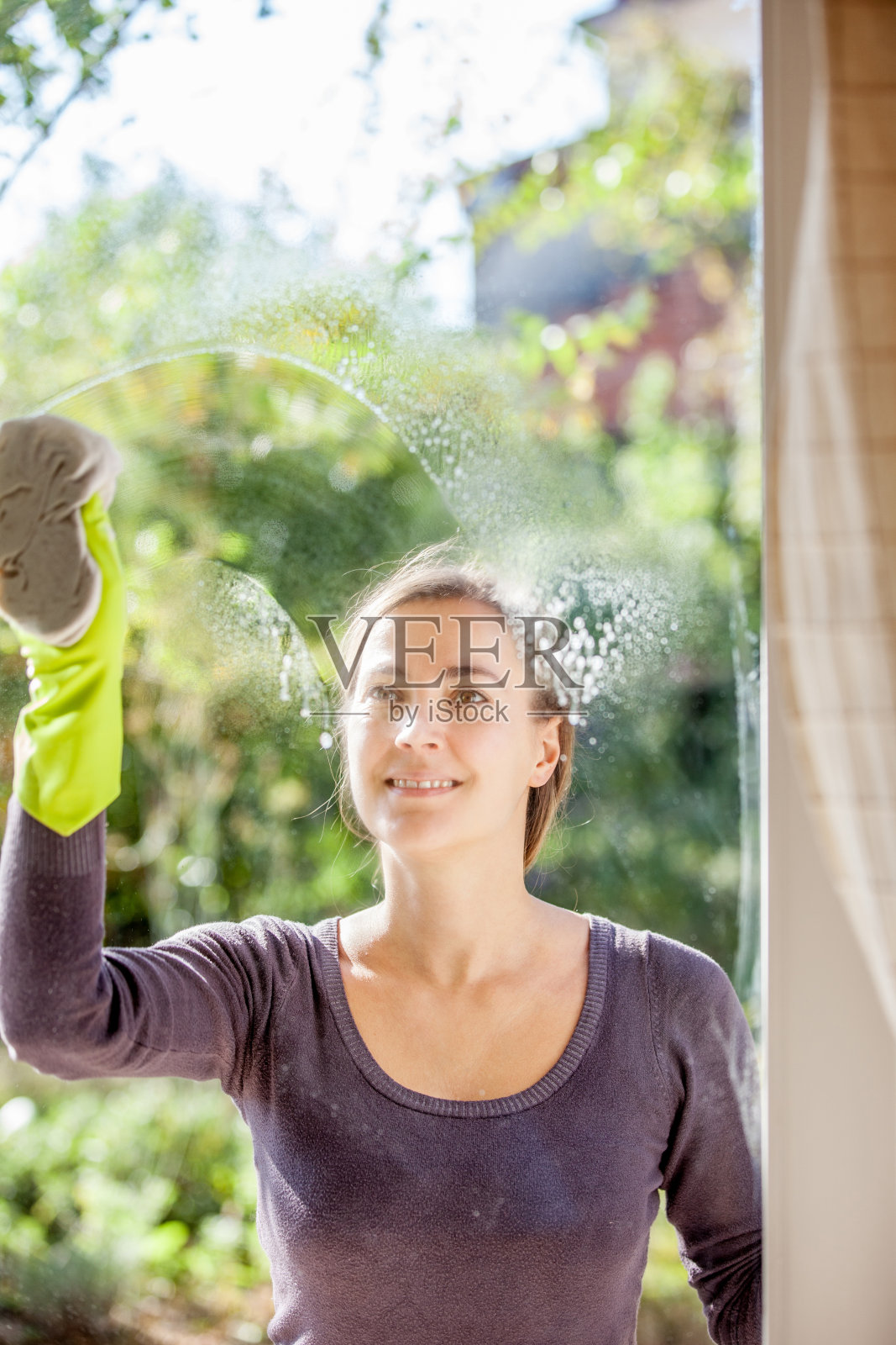 年轻女子擦窗户照片摄影图片