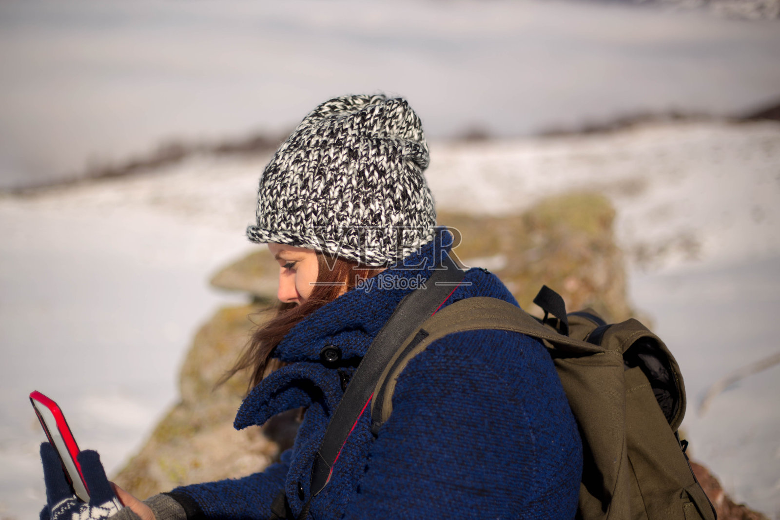 快乐微笑的女人在冬日里用智能手机自拍照片摄影图片