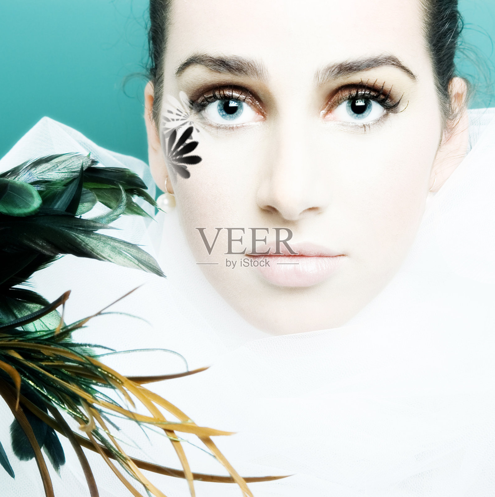 手持羽毛的年轻女人照片摄影图片