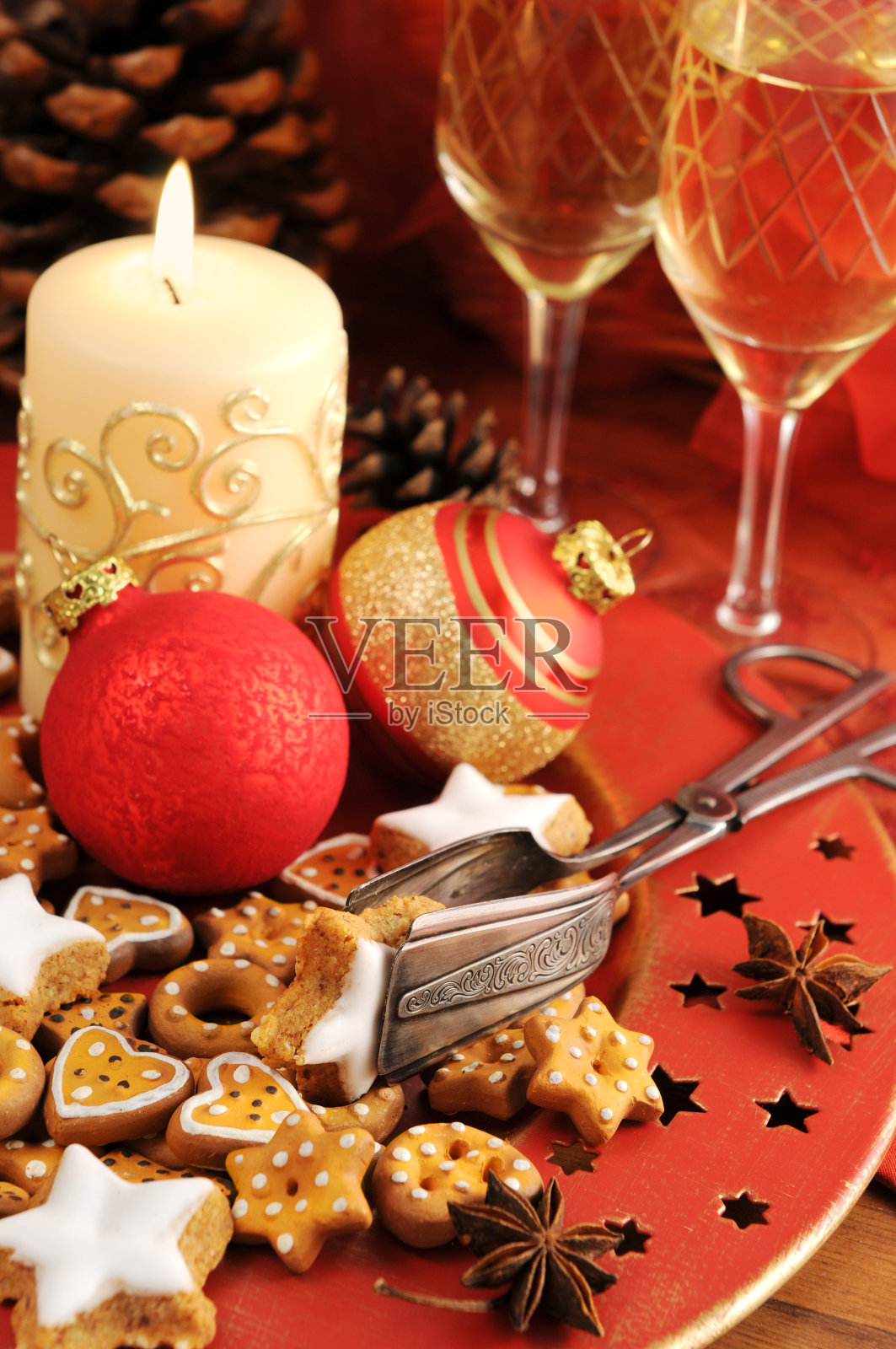 圣诞装饰桌上的酒杯，蜡烛，饼干照片摄影图片