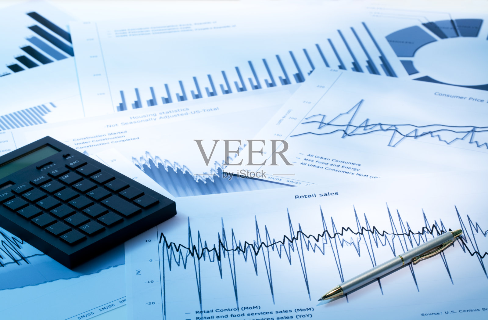 计算器和笔在一堆图形和图表上照片摄影图片