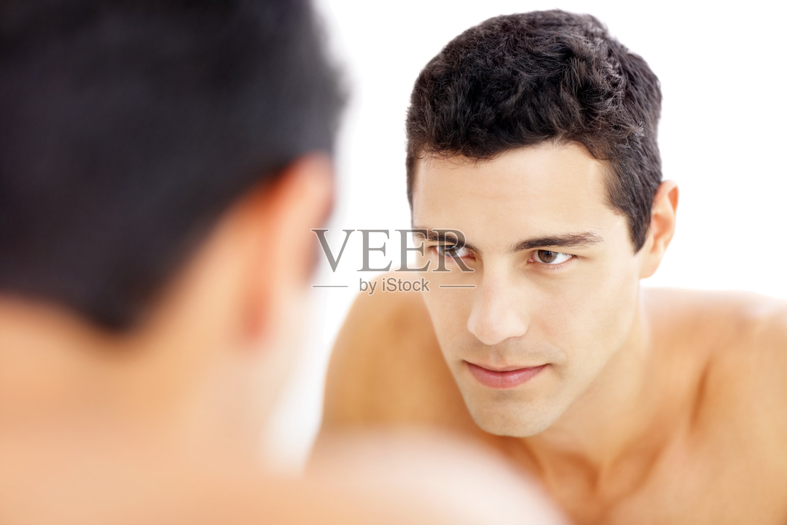 一个可爱的年轻人看着自己的倒影照片摄影图片