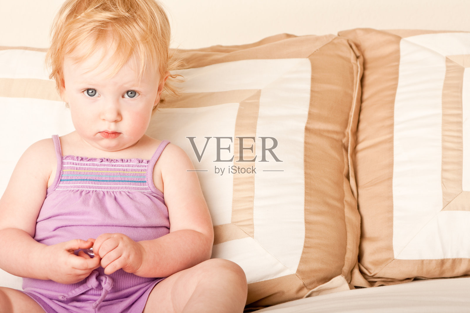 小女孩坐在床上照片摄影图片