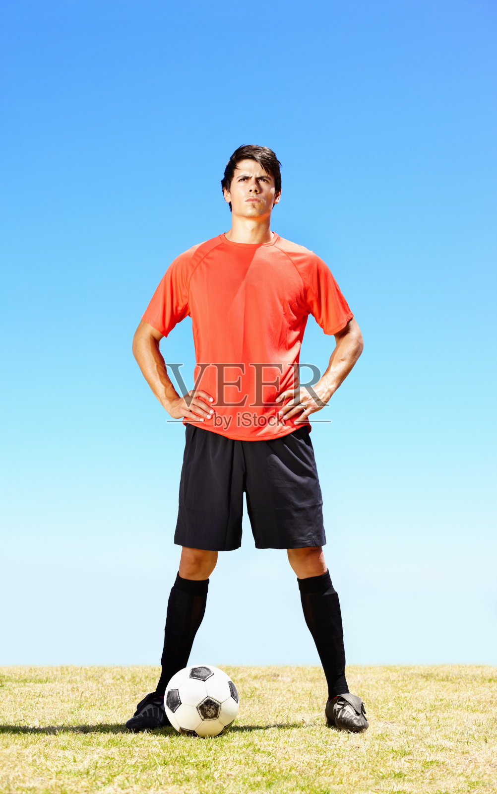 一个自信的足球运动员在球场上踢足球照片摄影图片