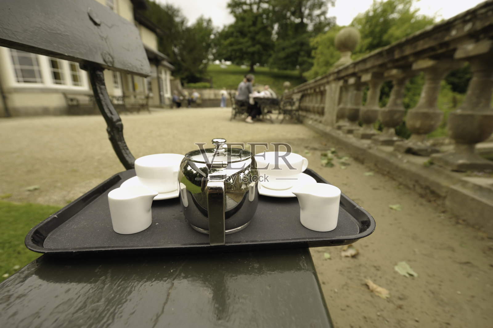 茶盘放在公园长凳上照片摄影图片