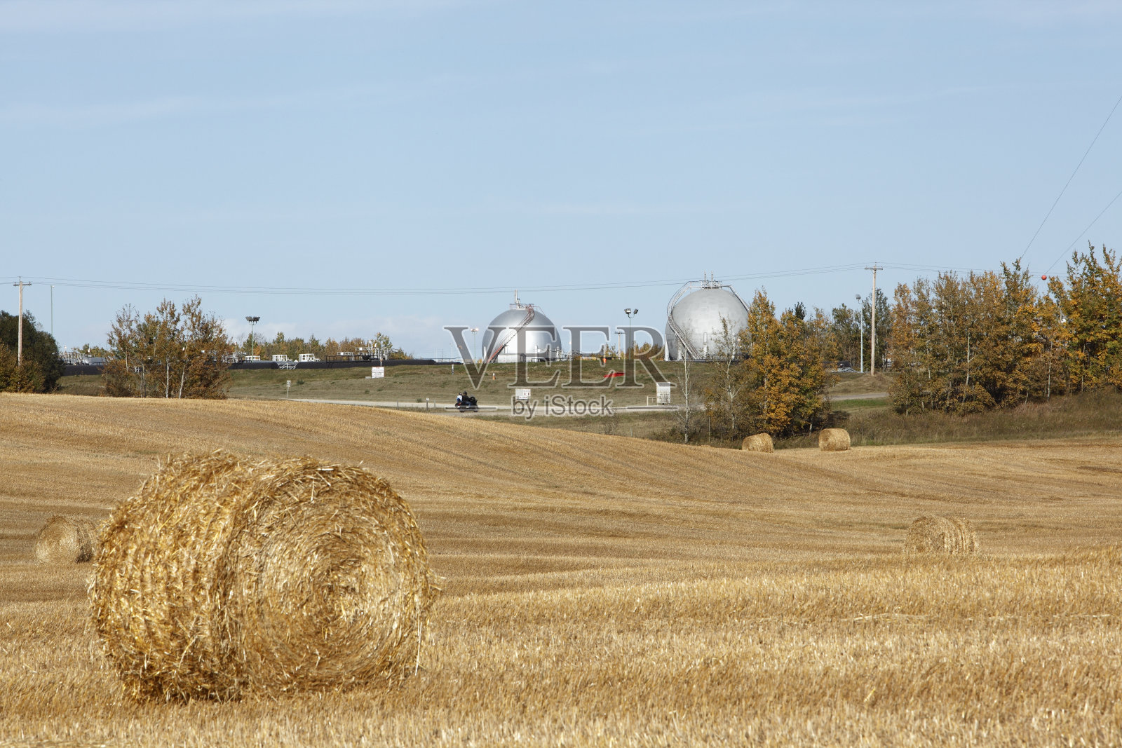有干草捆的油气燃料储存罐照片摄影图片