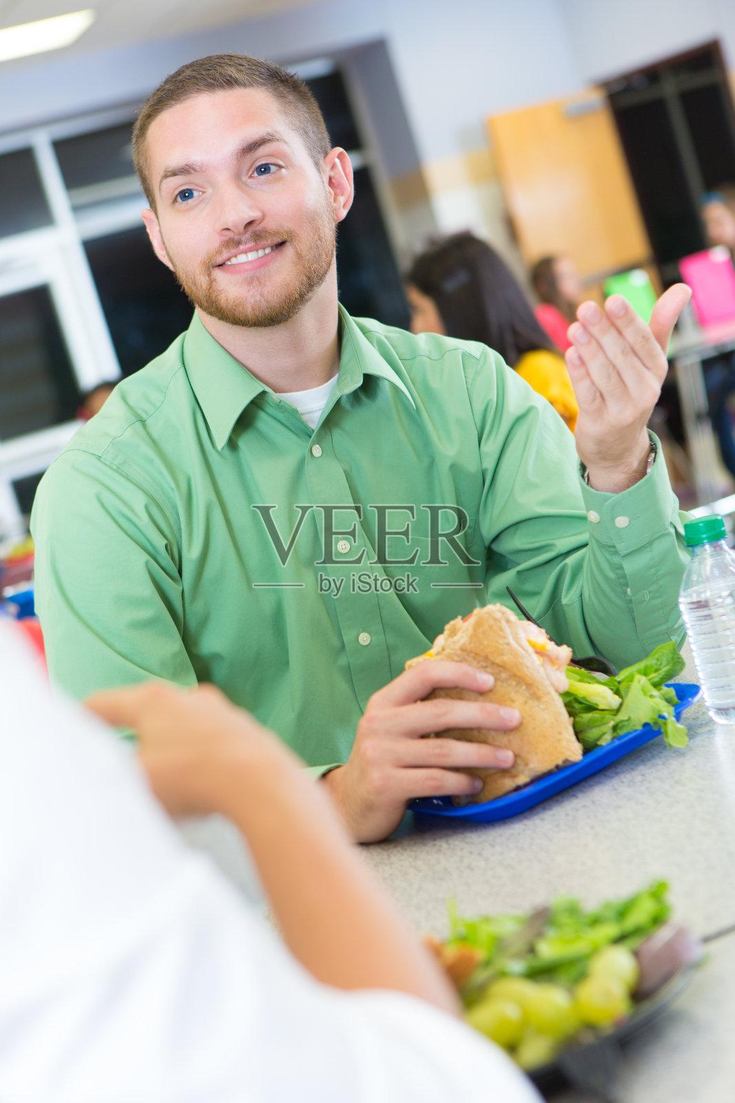 教育者在学校食堂边吃午饭边聊天照片摄影图片