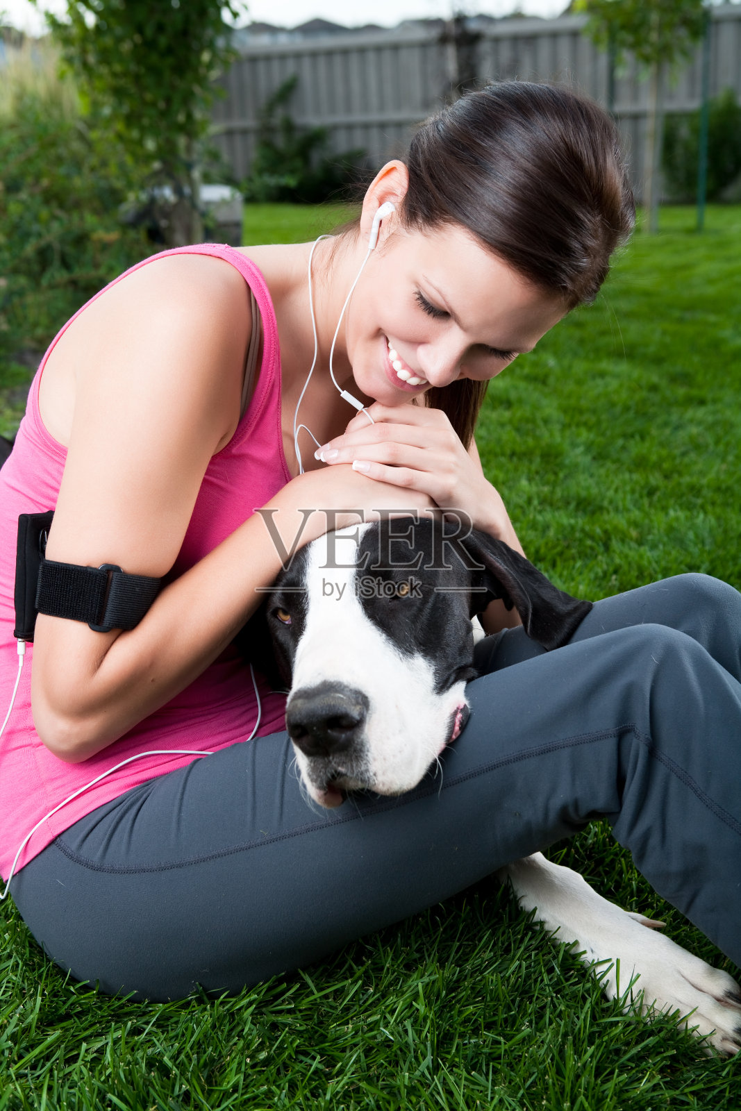 微笑的跑步者拥抱她的狗照片摄影图片