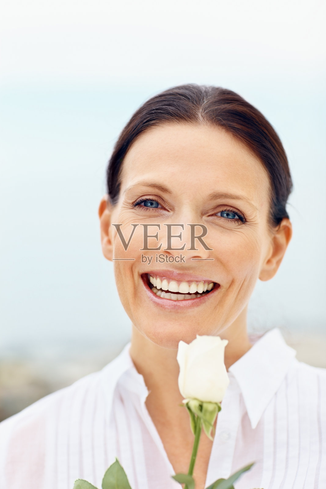 微笑的中年妇女拿着一朵花照片摄影图片