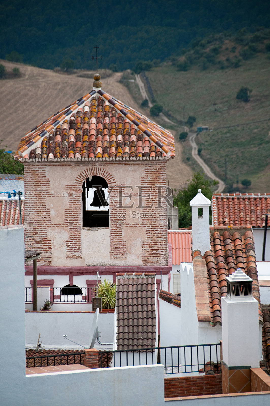 西班牙房屋和钟楼的瓦片屋顶照片摄影图片