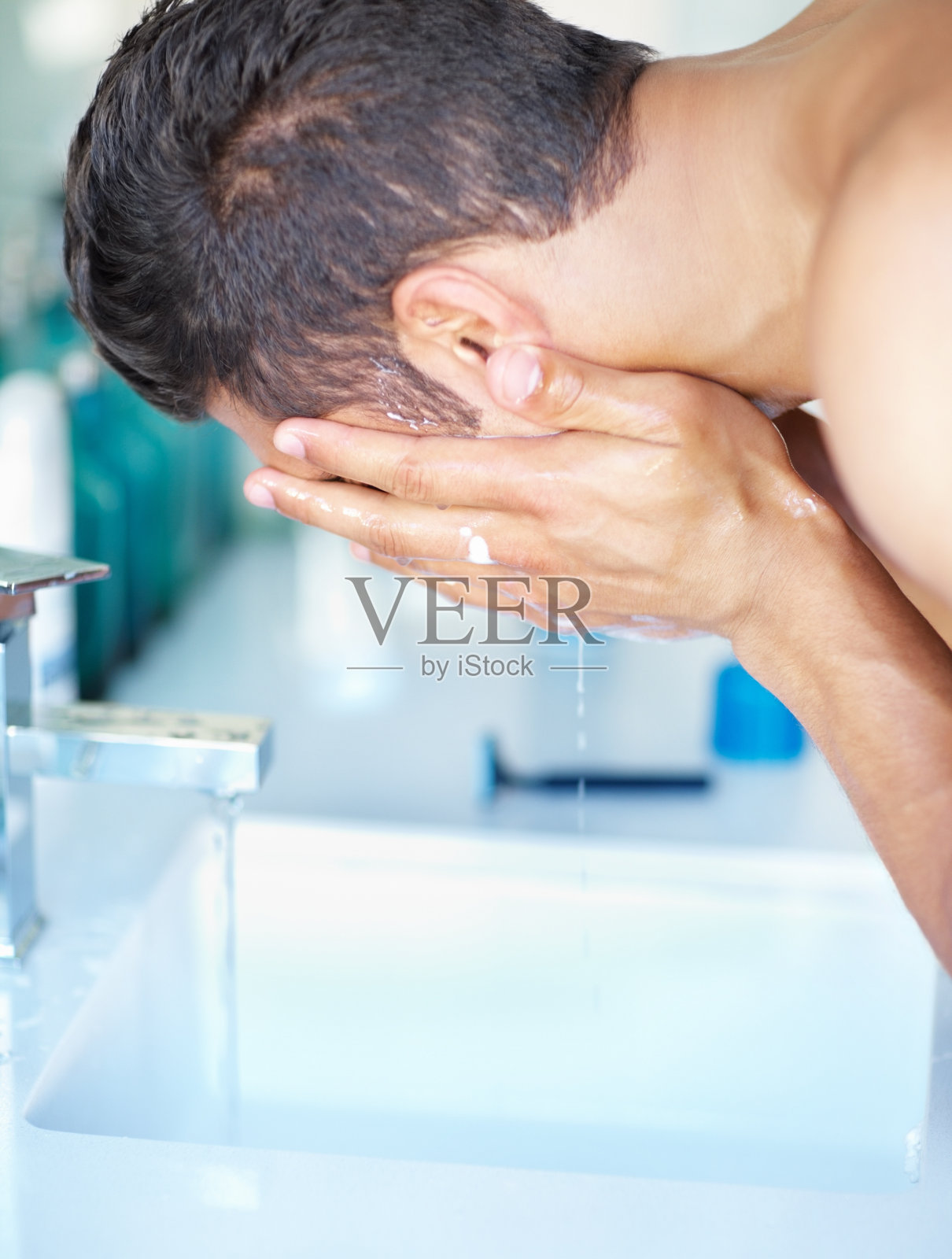 在水槽洗脸的年轻男人照片摄影图片