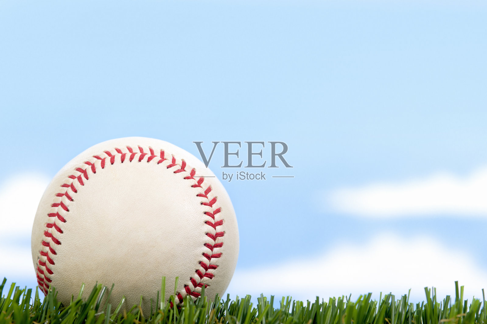 蓝天下的草地上的新棒球照片摄影图片