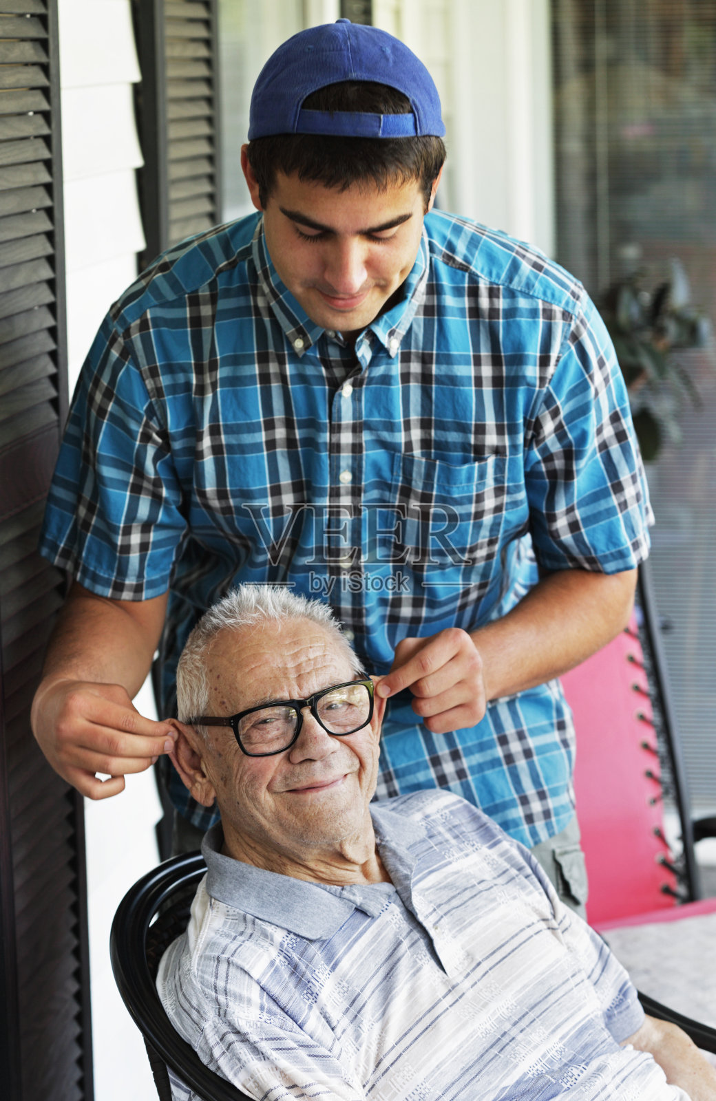 大学生孙子拉爷爷耳朵照片摄影图片