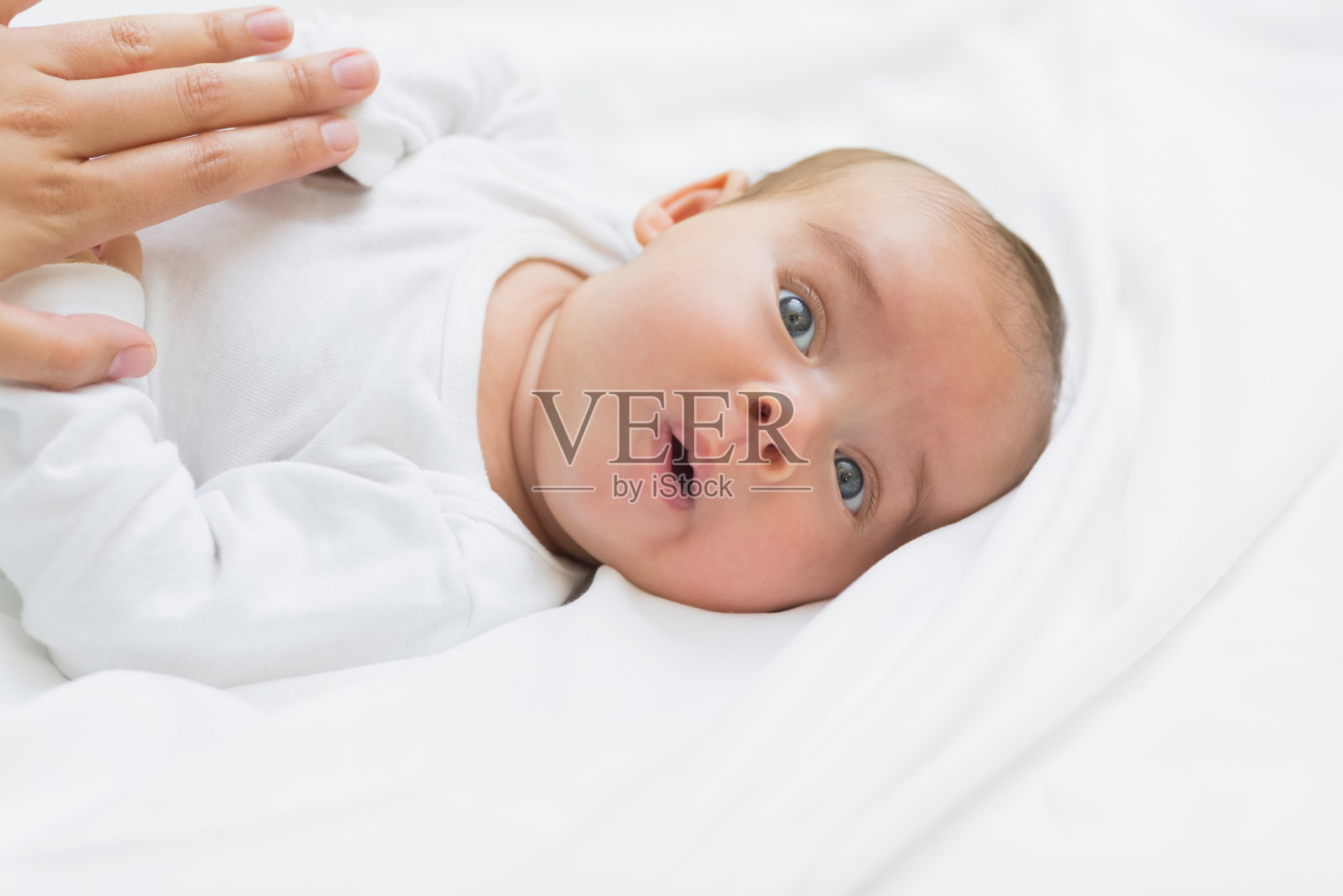 新生儿躺在床上照片摄影图片