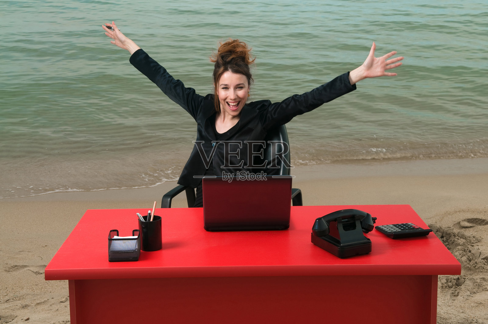 在海滩上工作的女商人照片摄影图片