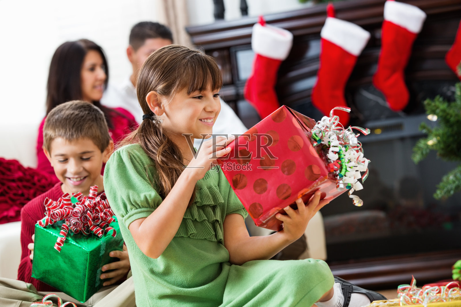 快乐的西班牙孩子和父母一起打开圣诞礼物照片摄影图片