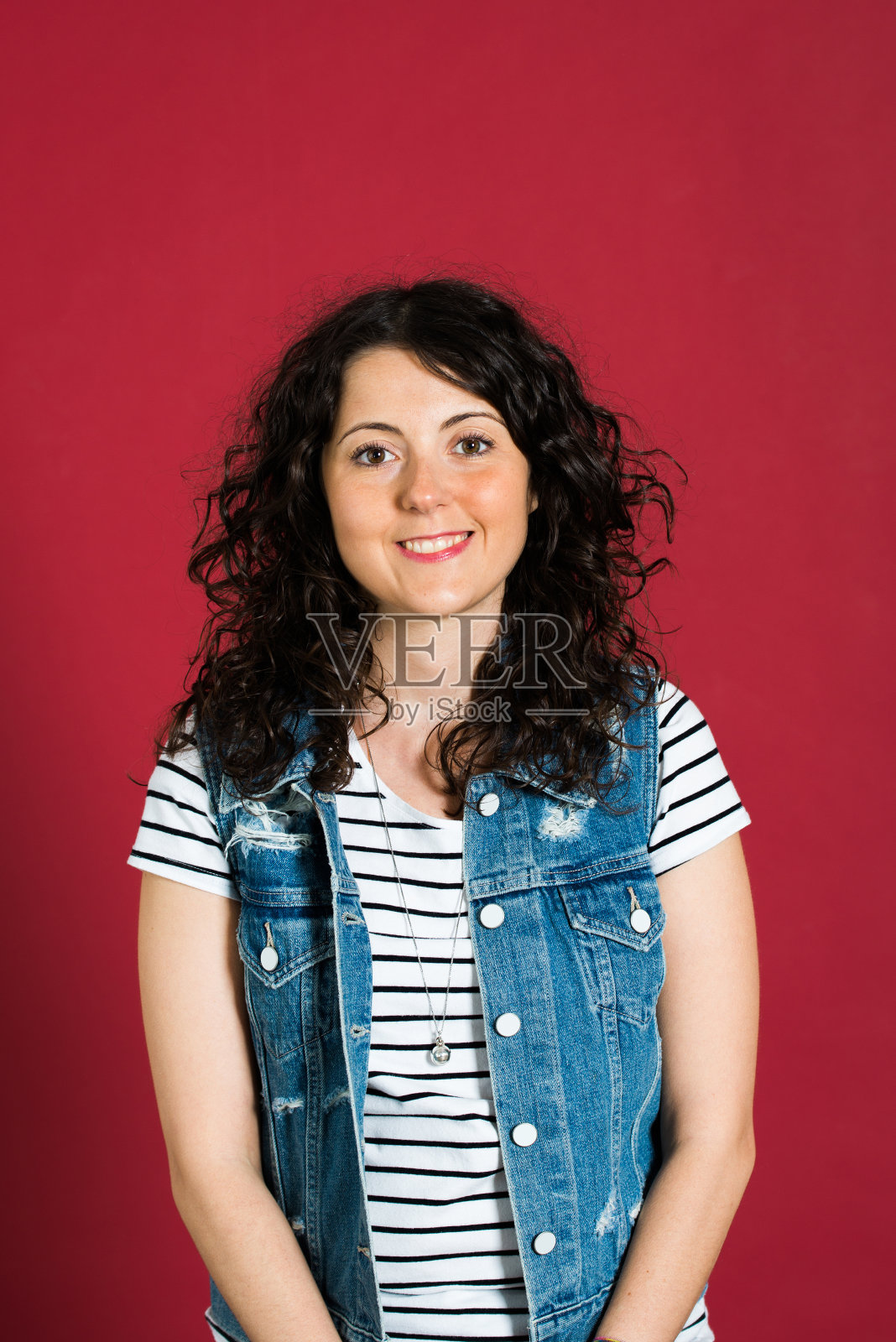 美丽的年轻女子在红色的背景下微笑照片摄影图片