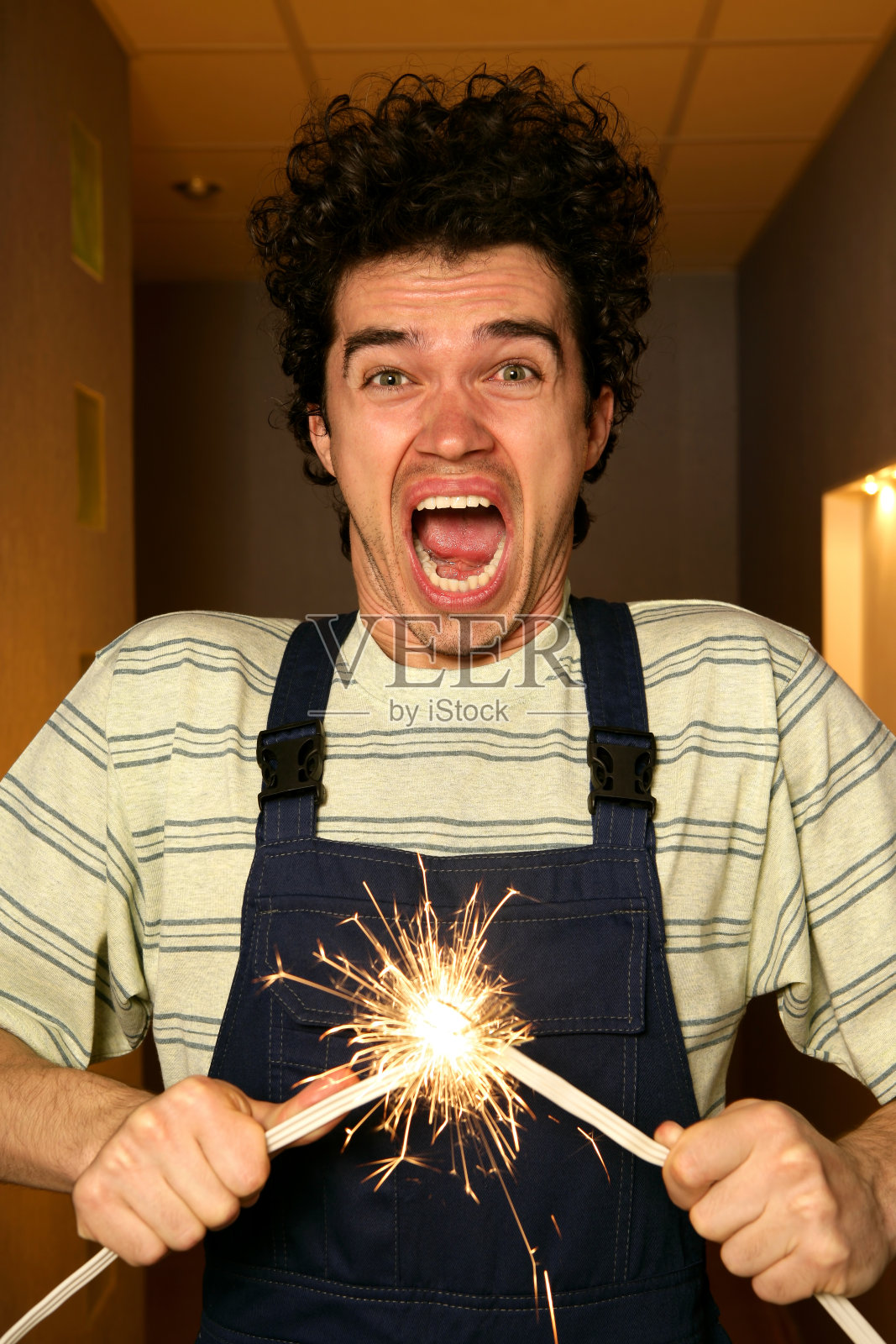 电击电工拿着闪亮的电线短路照片摄影图片