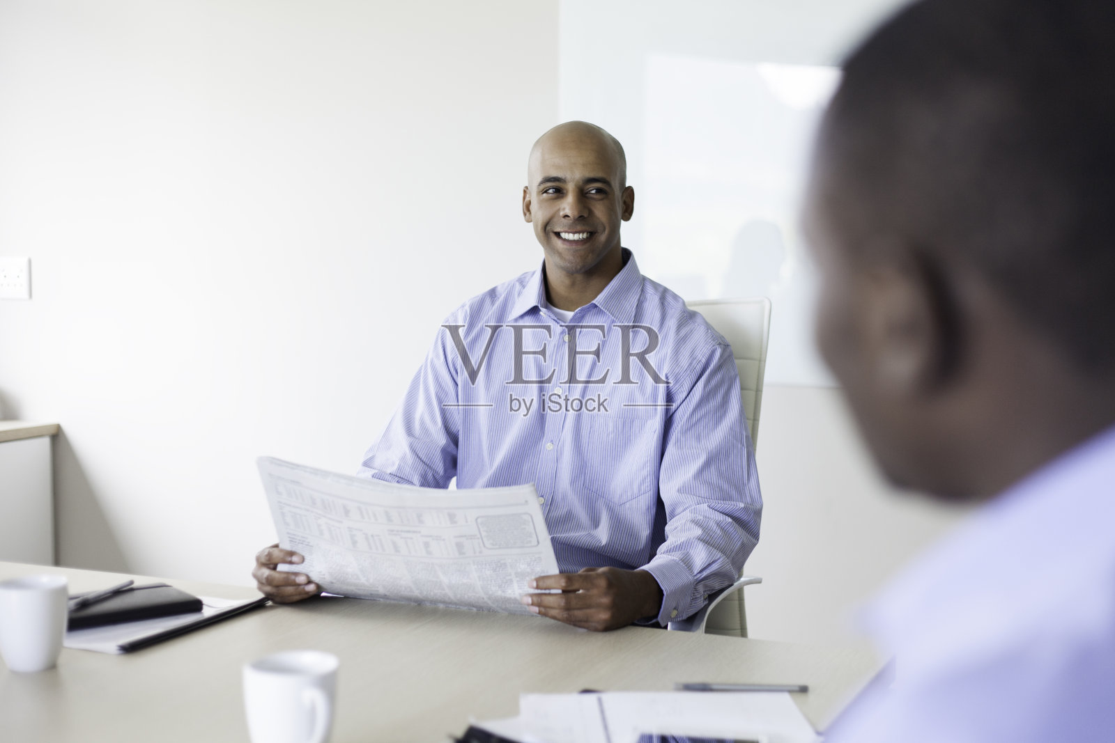 一个商人在会议上对他的同事讲话照片摄影图片