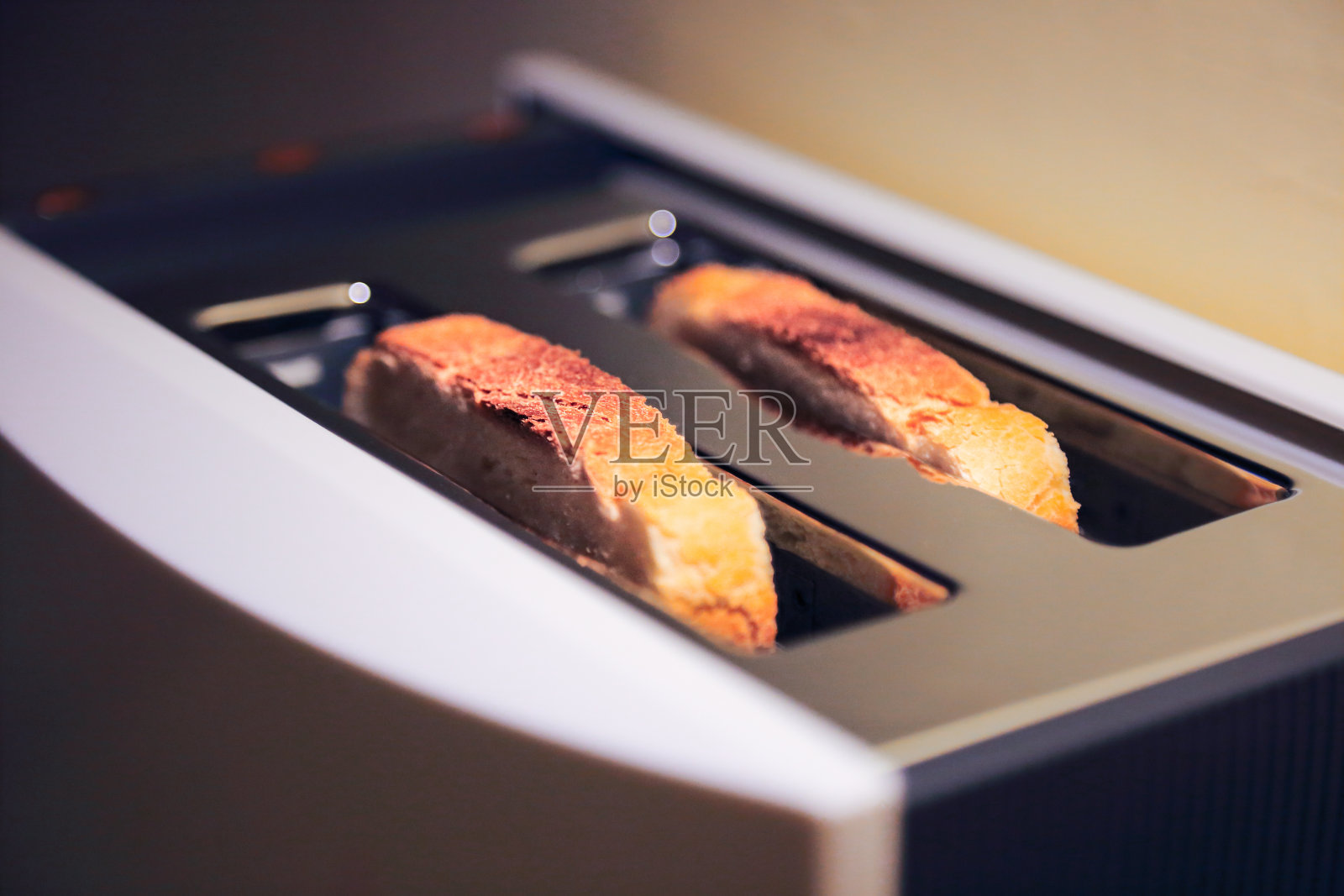 新鲜的金色吐司在现代烤面包机烘烤。照片摄影图片