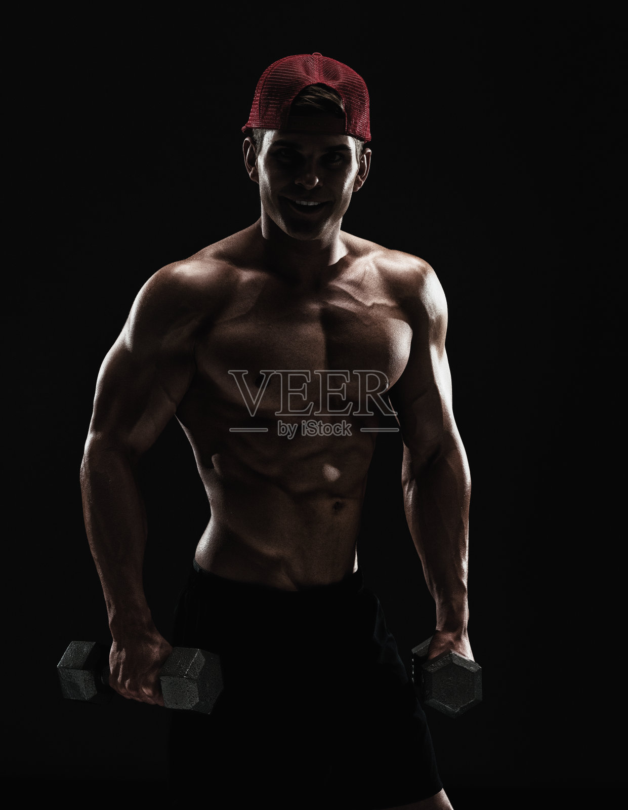 赤膊肌肉男用哑铃锻炼照片摄影图片