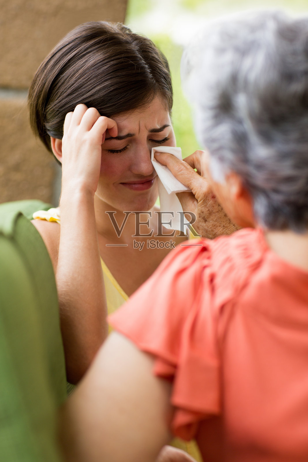 年长的女人安慰哭泣的孙女照片摄影图片
