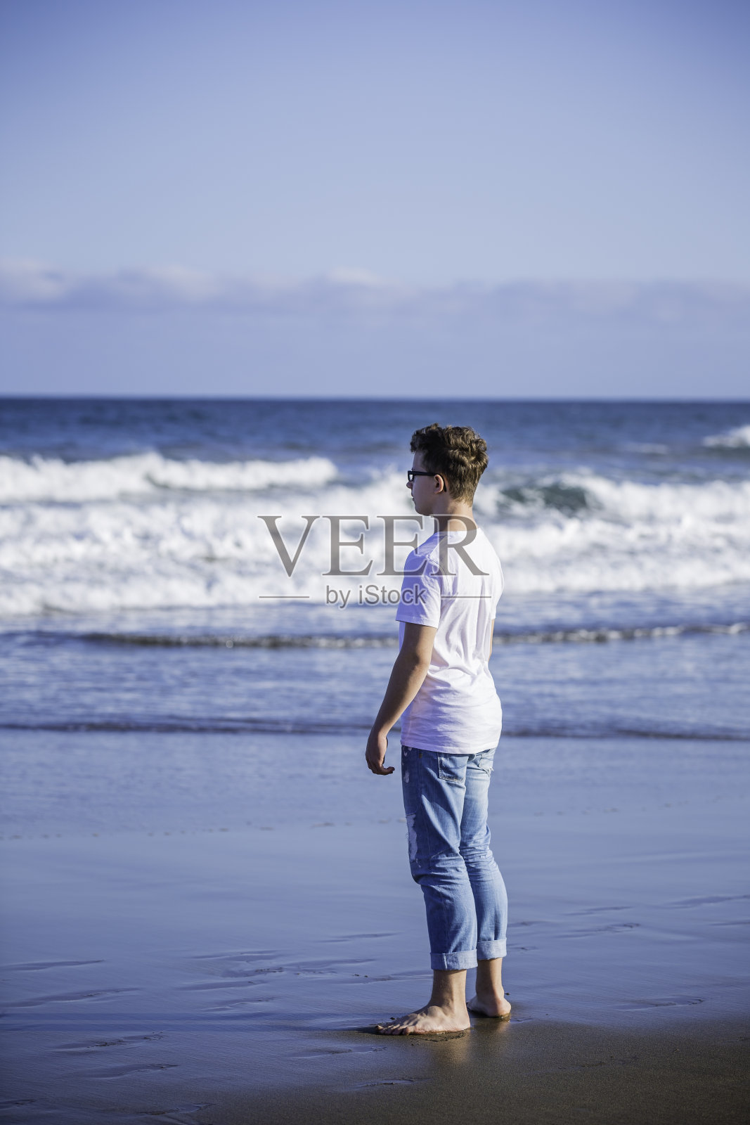 男孩在海滩上散步照片摄影图片