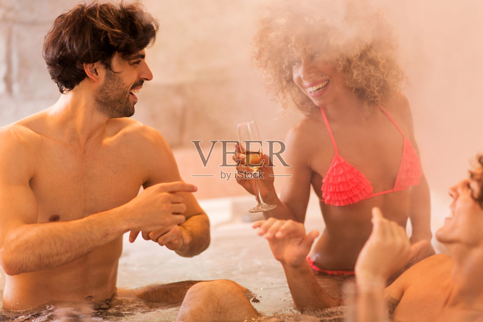 在热水浴缸里玩得开心。照片摄影图片