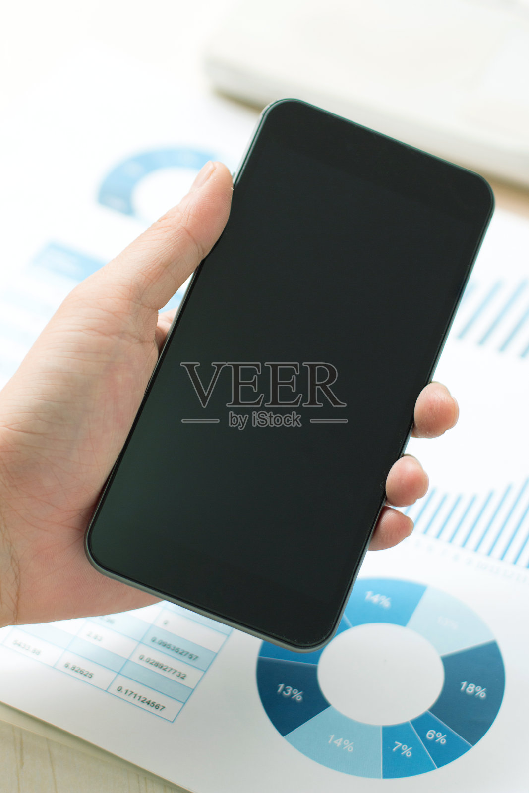 商人使用手机分析公司财务报告照片摄影图片