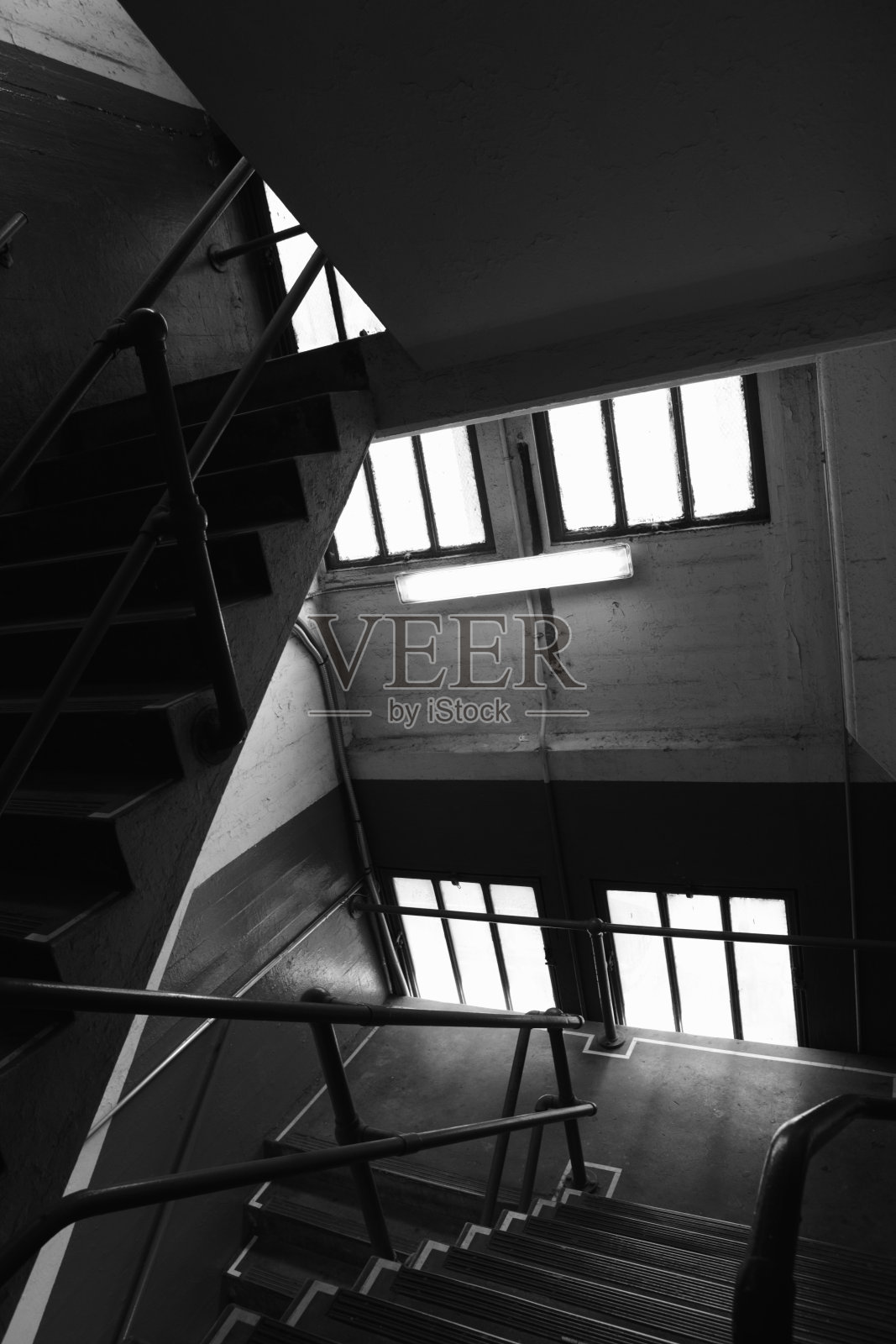 黑暗的楼梯间在旧的混凝土工业建筑明亮的窗户照片摄影图片