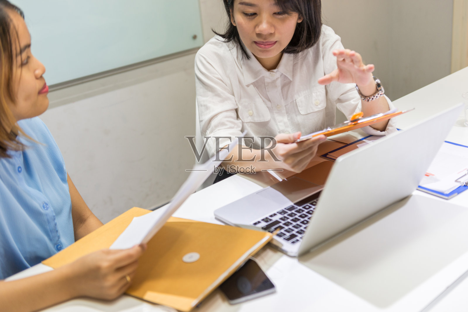 两个团队成员在谈论笔记本电脑上的销售图表报告照片摄影图片