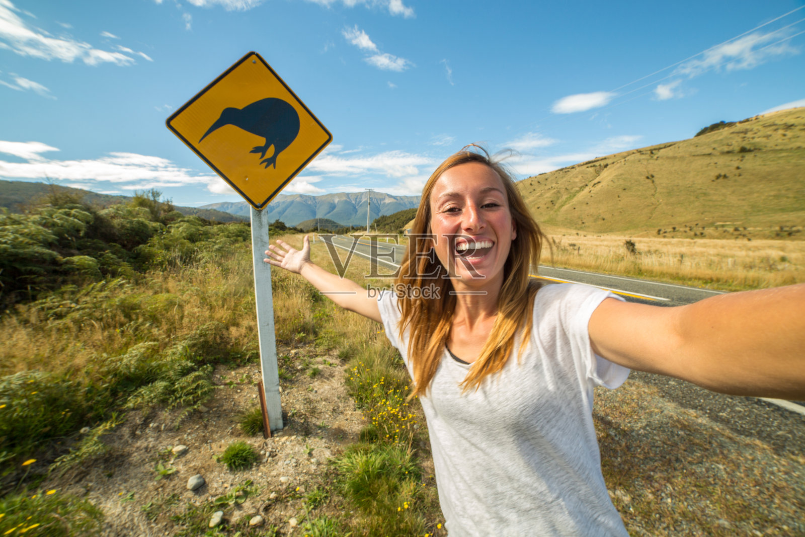 旅行中的女孩在路上用猕猴桃标志自拍照片摄影图片