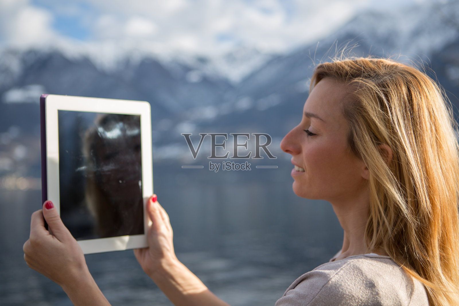 女人使用平板电脑拍摄风景照片摄影图片
