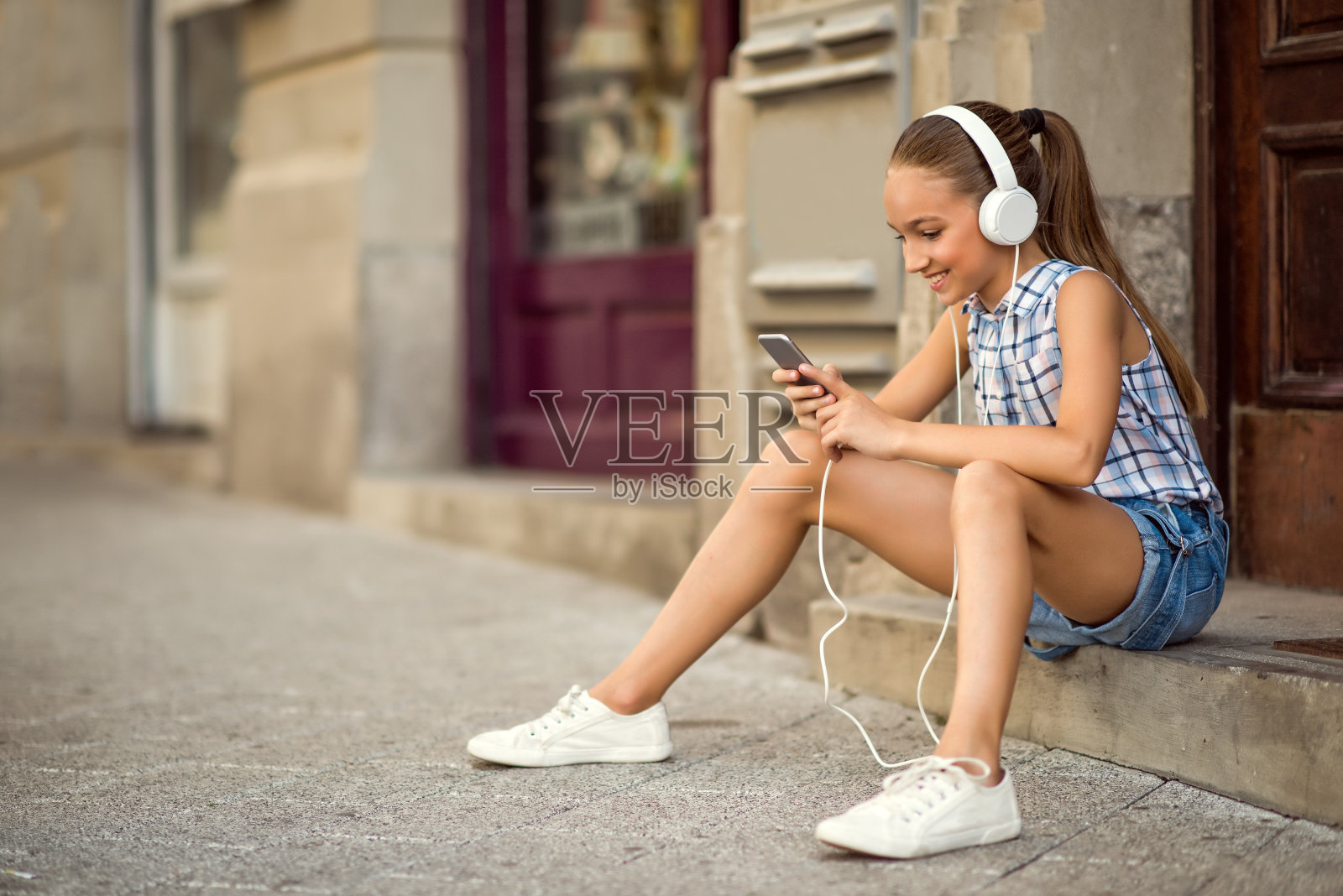 女孩用手机听音乐照片摄影图片