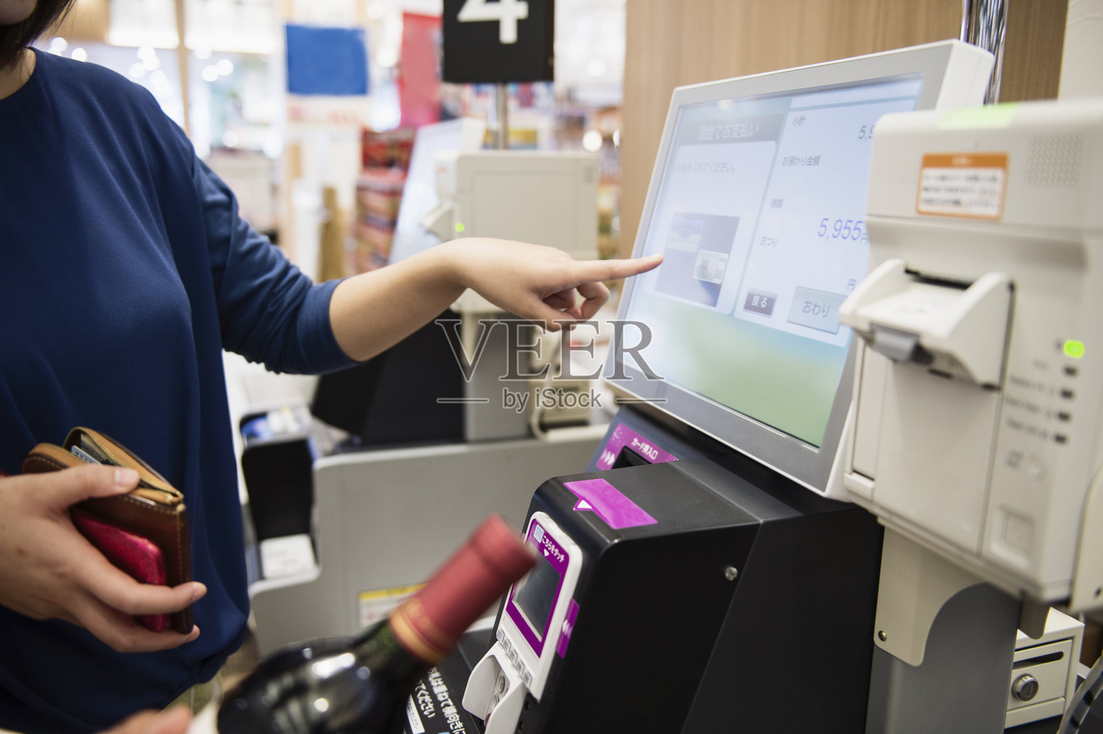 年轻女子在使用自助收银机照片摄影图片