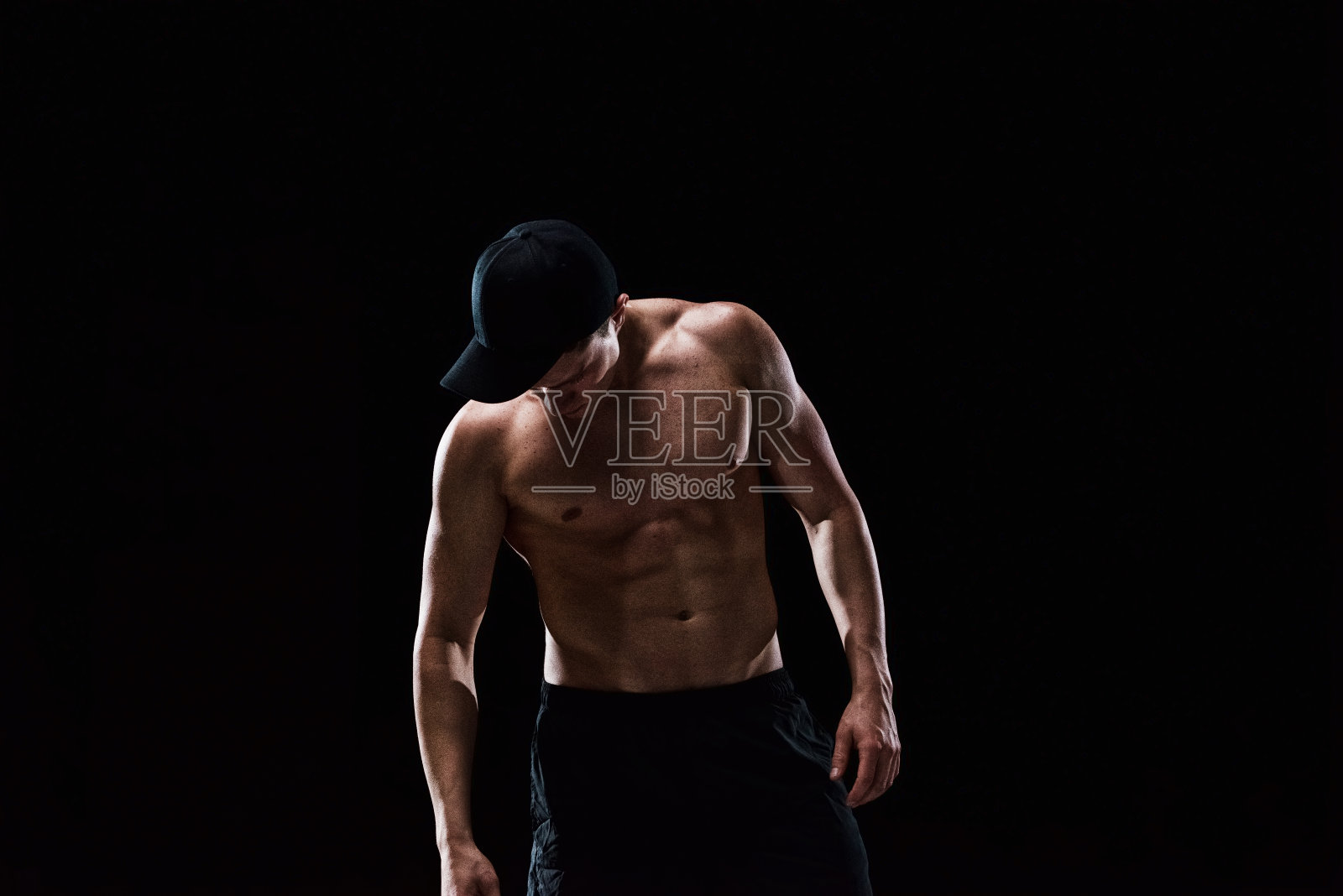 赤裸上身的肌肉男向下看照片摄影图片