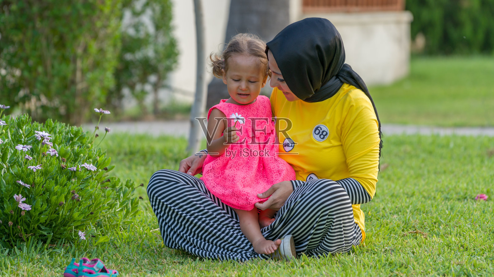 穆斯林家庭母亲和女儿在绿草地上照片摄影图片
