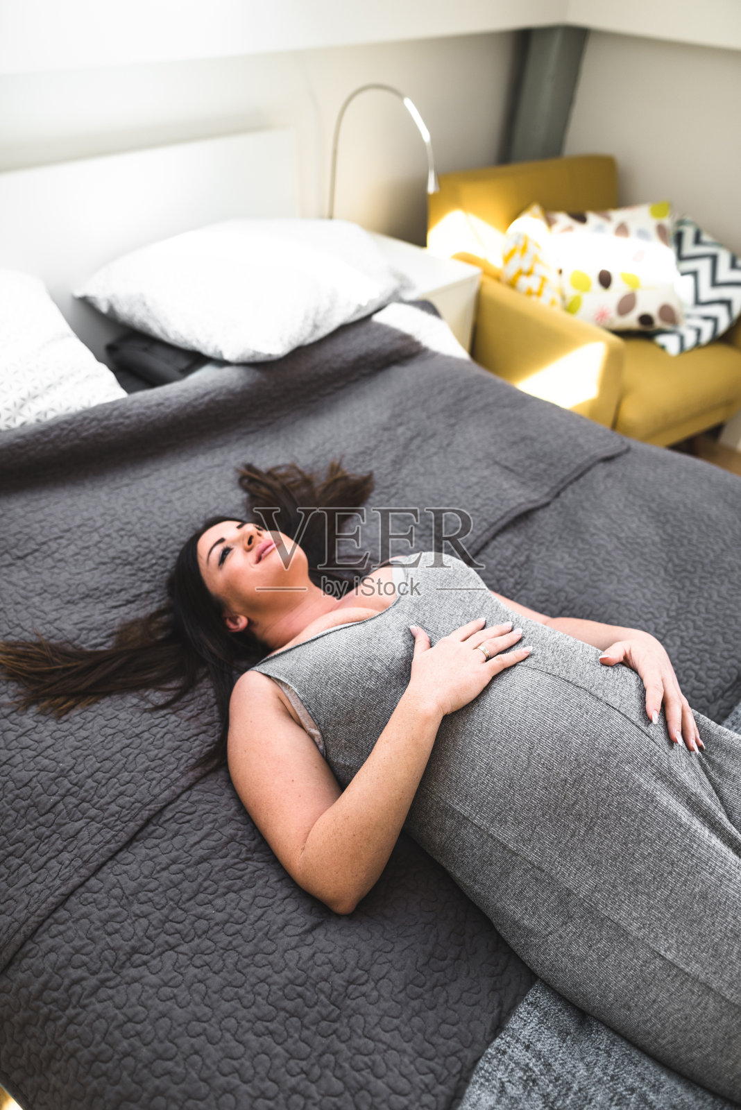 孕妇躺在床上休息照片摄影图片