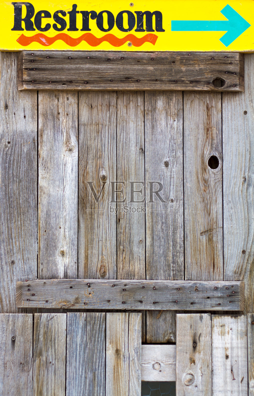 “厕所”:旧木墙上的黄色标志照片摄影图片