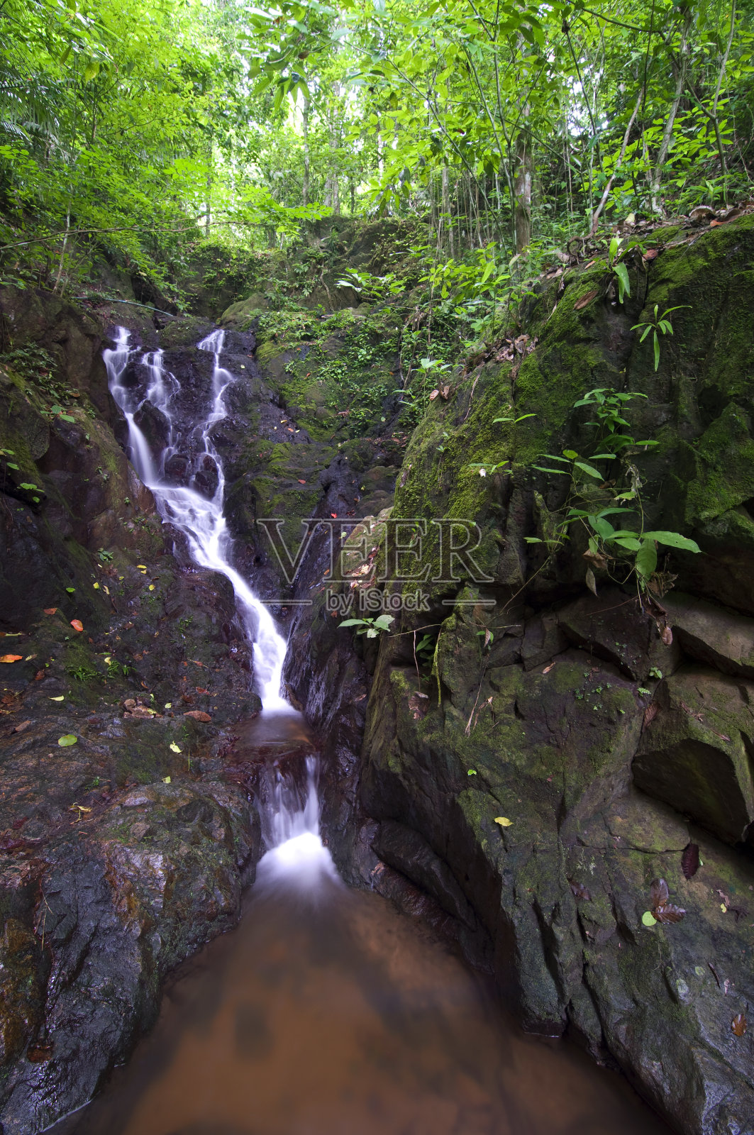 柔软的瀑布在山上与树木照片摄影图片