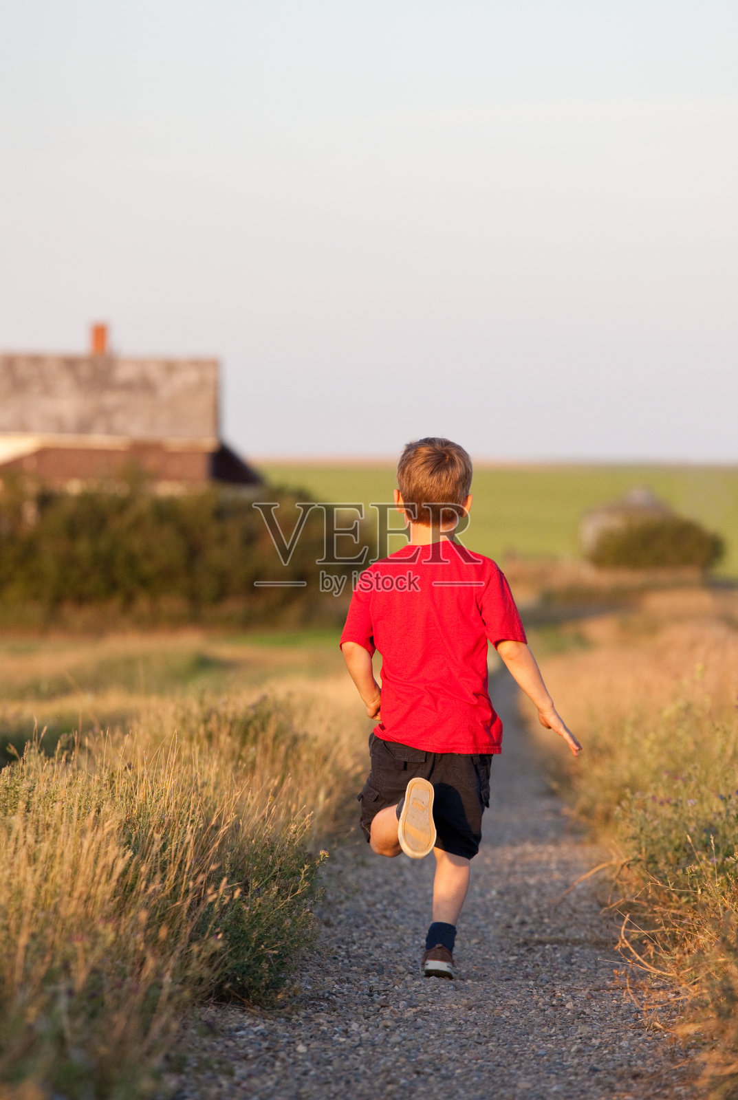 乡村小路上奔跑的小男孩照片摄影图片