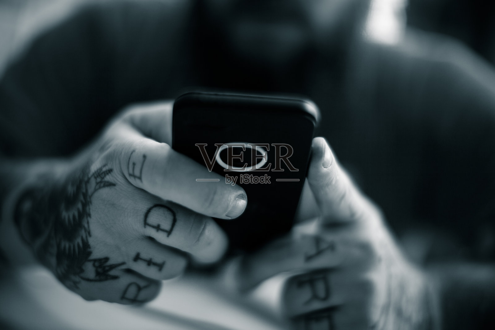 纹身男子使用智能手机照片摄影图片