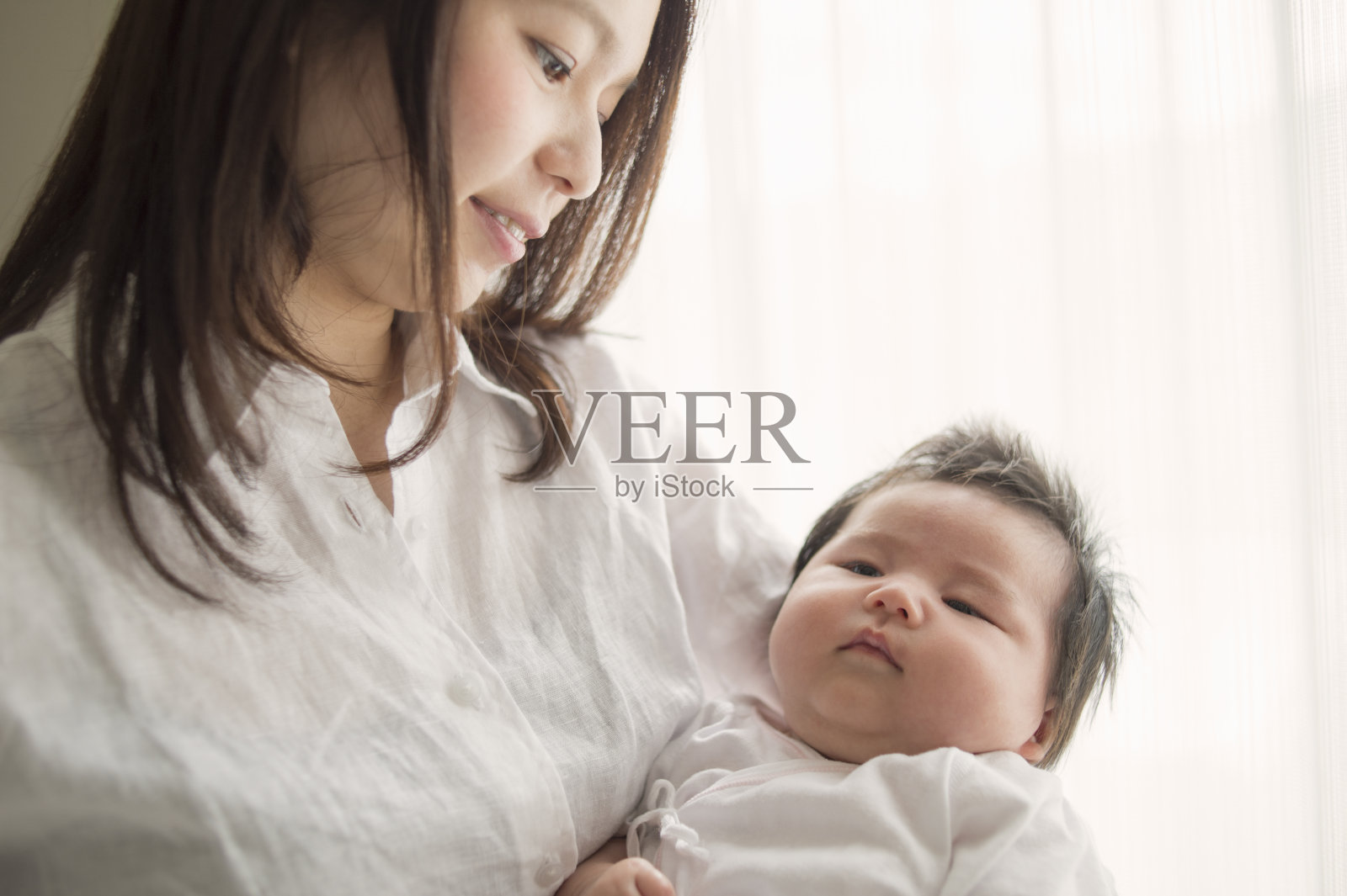 年轻的母亲在家里爱着她的宝贝女儿照片摄影图片