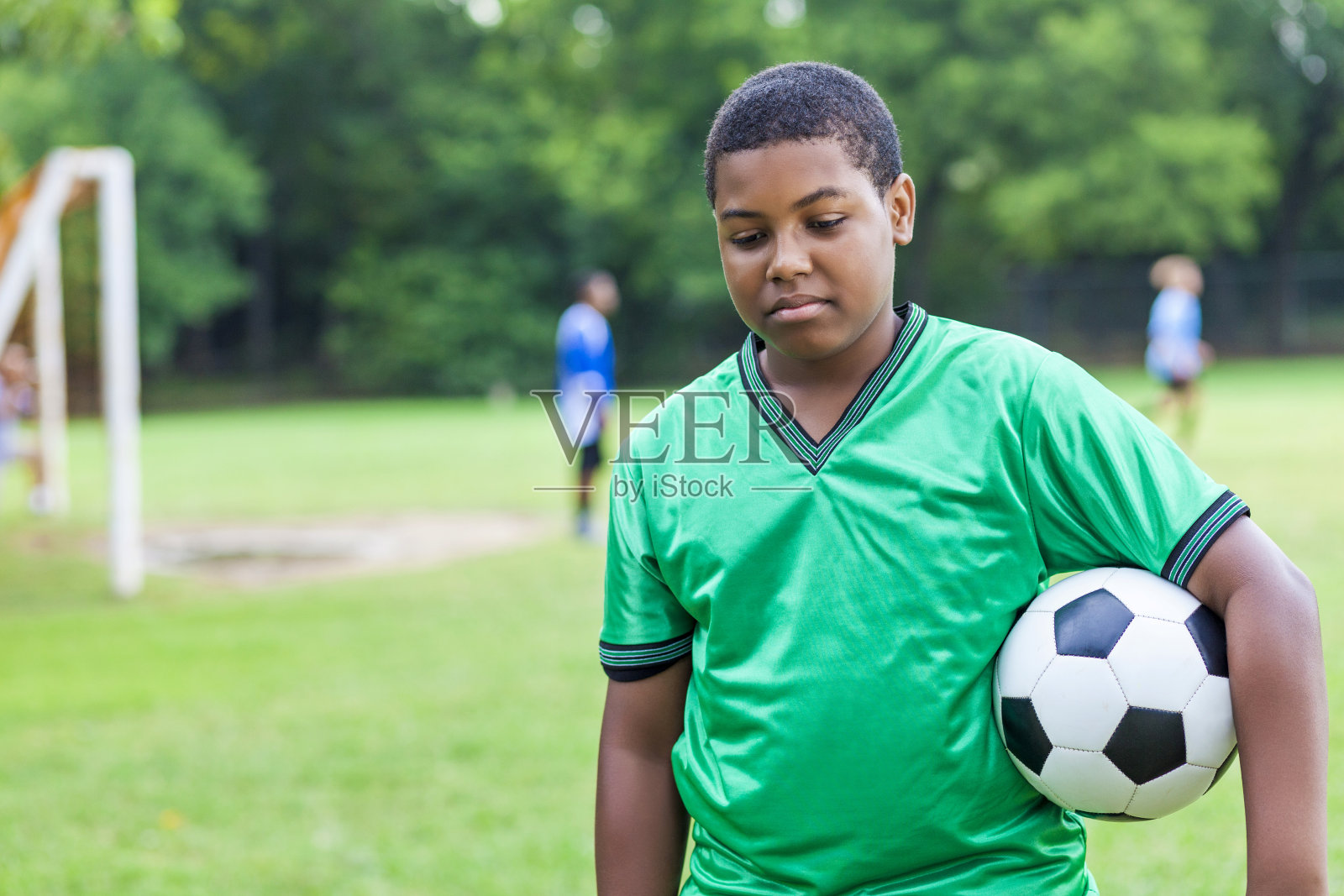在输掉一场足球比赛后，沮丧的年轻非洲裔美国球员照片摄影图片