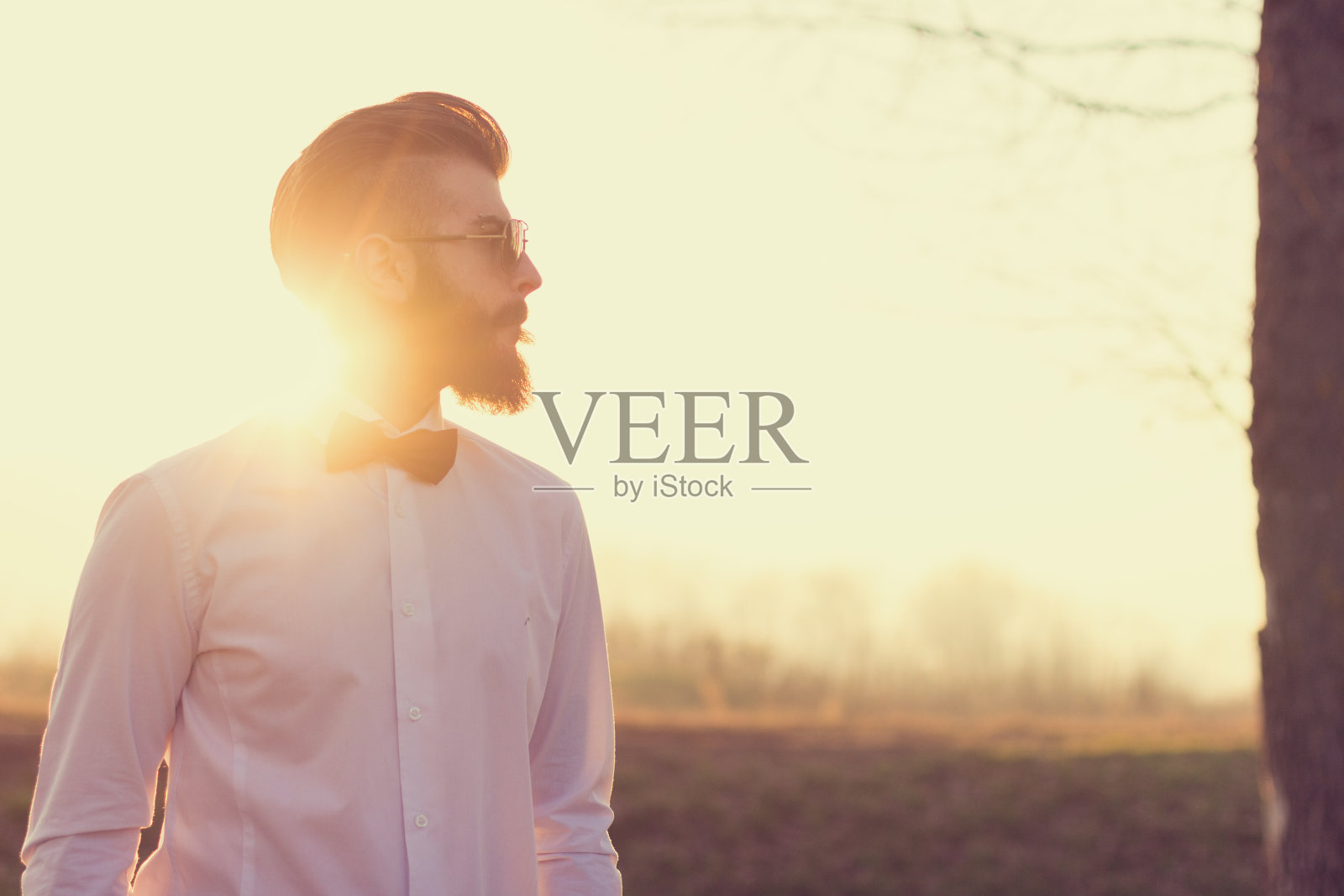 帅气时髦的男人戴着太阳镜对着阳光摆姿势照片摄影图片