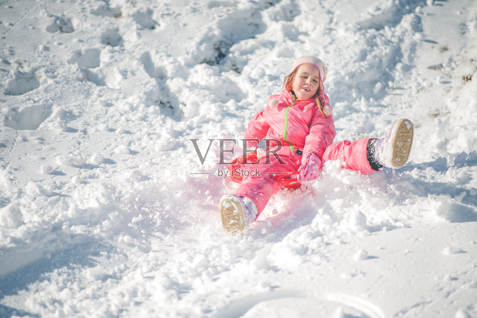 孩子在雪地上滑倒了照片摄影图片