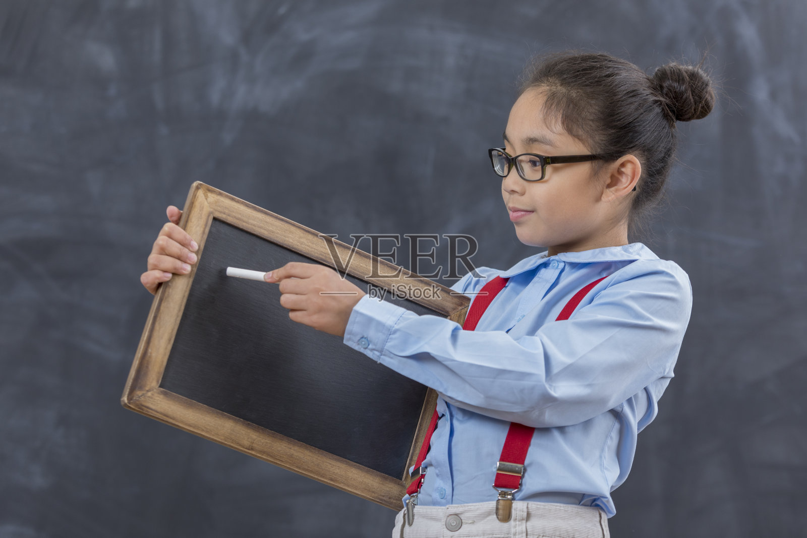 女孩在课堂上在小黑板上写字照片摄影图片