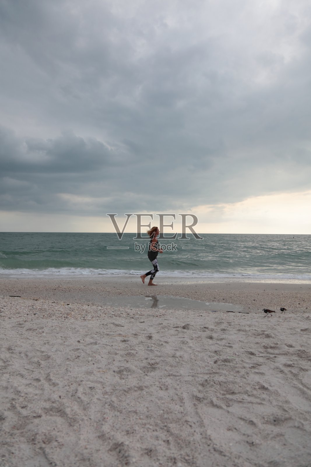 在海滩上慢跑。照片摄影图片