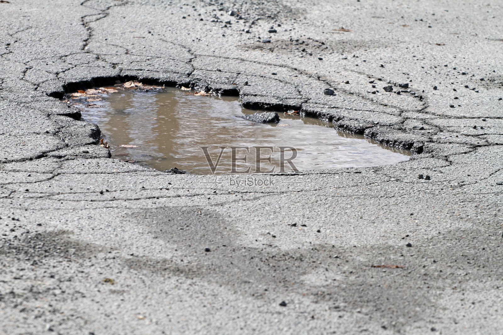 道路上的坑洼，导致危险驾驶条件照片摄影图片