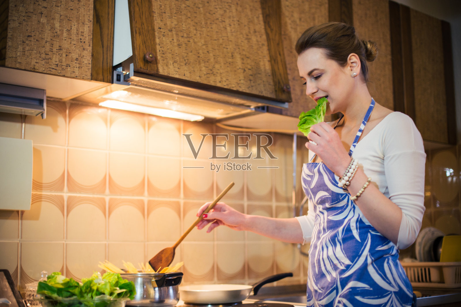 一个可爱的女人在做餐盘，还吃了点健康小吃照片摄影图片